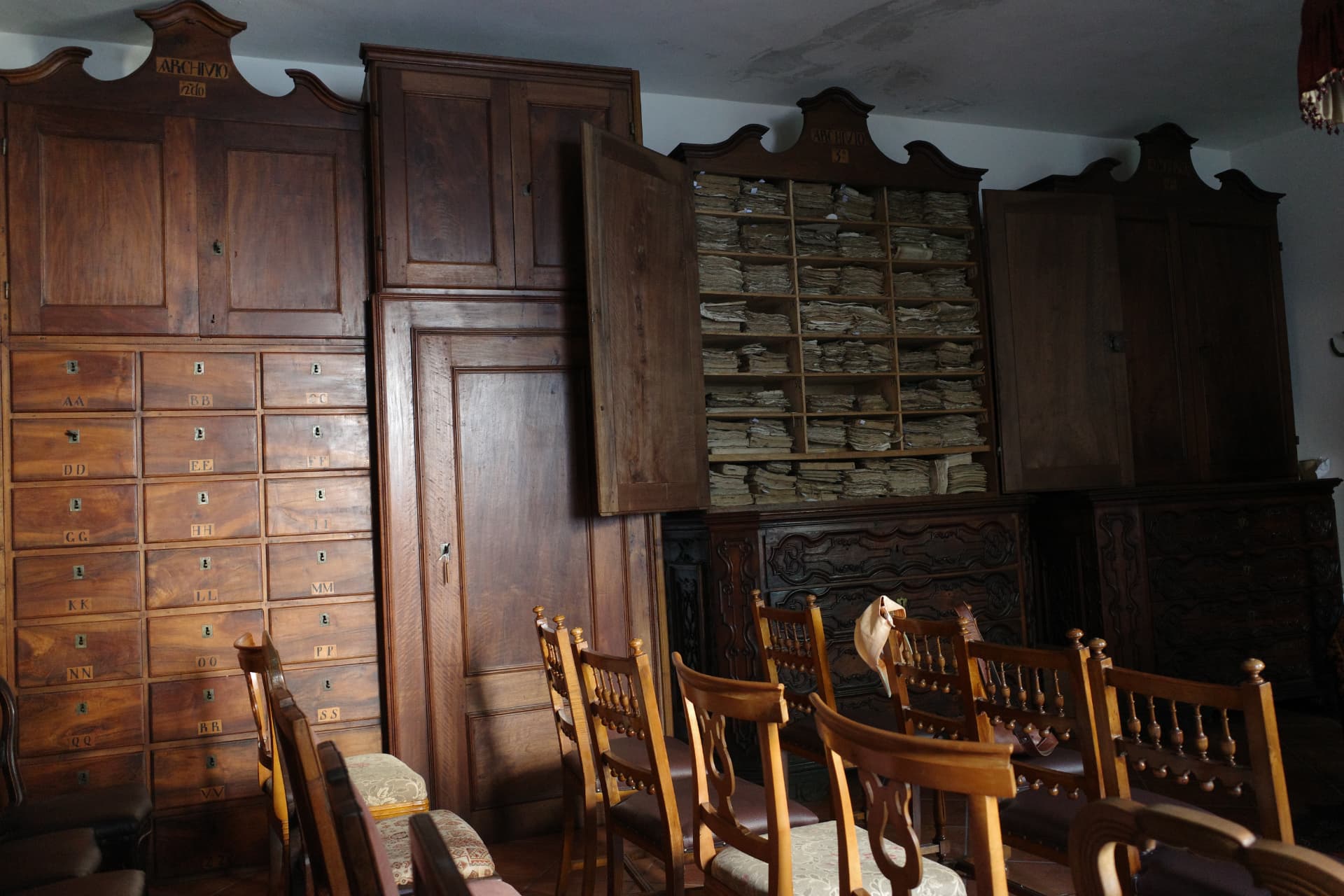 Arkivrummet med höga träskåp märkta Archivio, bokstavsmärkta lådor och ett öppet skåp fyllt av handlingar